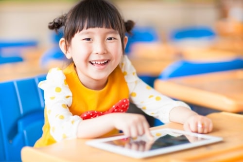 petite fille avec un iPad en classe